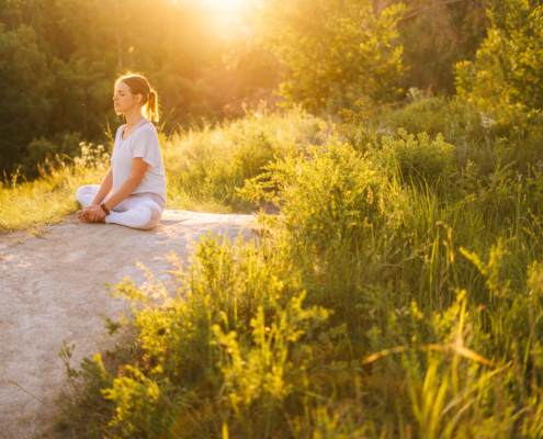 Image of a woman sitting on a rock peacefully. This image represents mindfulness skills, which a DBT therapist can teach for those using self-harm in Los Angeles, CA. 90277 | 90254