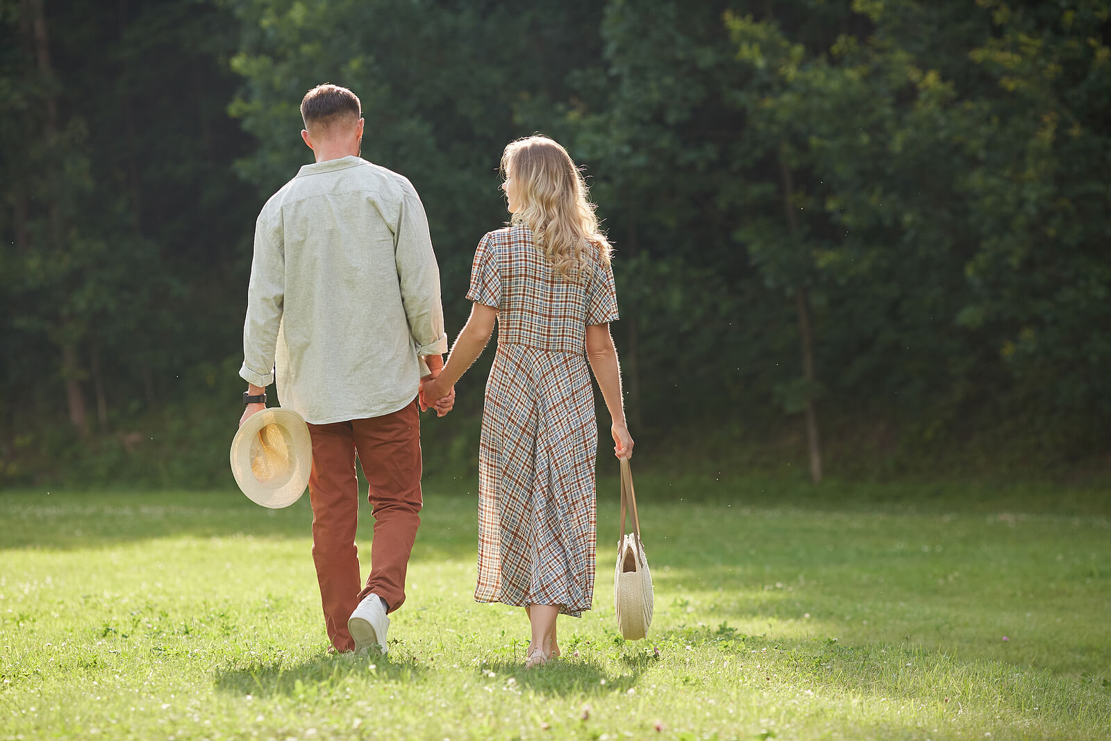Image of a couple smiling and holding hands as they walk across grass. Find helpful places to date your partner in Las Vegas, NV here! Create positive changes in your life with the help of DBT therapy in Las Vegas, NV!