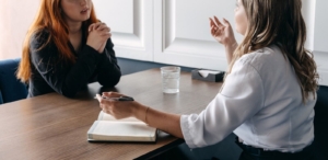 Image of two women sitting at a table having a serious conversation. Learn how effective EMDR therapy in Las Vegas, NV can be when managing your depression symptoms.