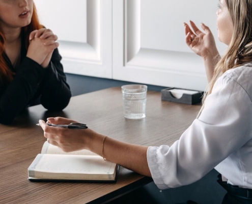 Image of two women sitting at a table having a serious conversation. Learn how effective EMDR therapy in Las Vegas, NV can be when managing your depression symptoms.