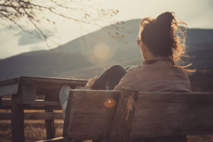 Image of a woman sitting on a bench while the sun sets. Do you struggle with anxiety? Learn how EMDR therapy in Las Vegas, NV can help you heal from your symptoms.