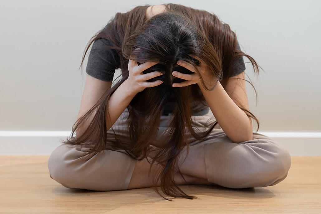 Image of a woman sitting on the floor with her head in her hands upset. Do your BPD symptoms get in the way of everyday life? Learn to effectively manage your symptoms with the help of borderline personality disorder therapy in Las Vegas, NV.
