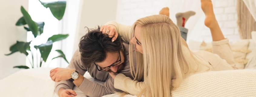 Image of a playful couple smiling while laying in bed. Discover how borderline personality disorder therapy in Las Vegas, NV can help you connect with others in healthy ways.