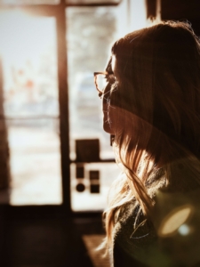 Image of a woman looking out a window with the sun shining on her face. Discover how EMDR therapy in Las Vegas, NV can help you cope with your depression symptoms.