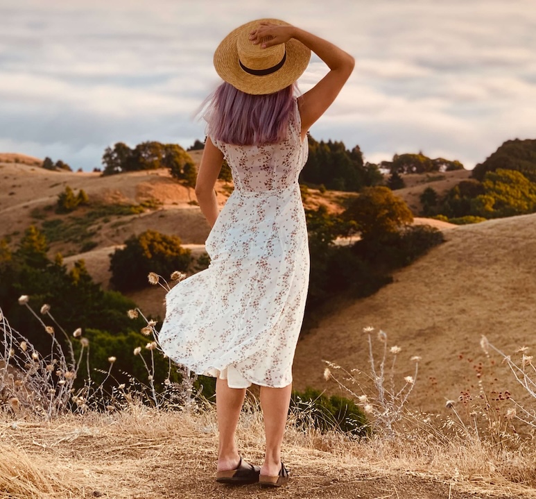 Image of a woman standing on top of a desert hill holding her hat on her head. If you struggle with managing your depression, learn how EMDR therapy in Las Vegas, NV can help you cope and move forward.