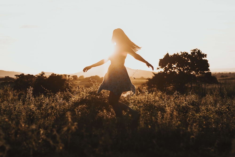Image of a woman twirling in a field during sunset. Learn healthy ways you can cope with anxiety by starting EMDR therapy in Las Vegas, NV.