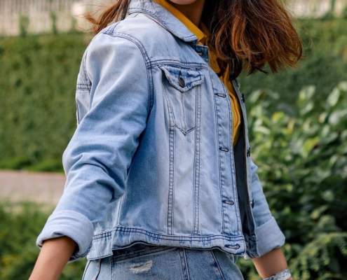 Image of a smiling Asian woman turning around wearing a jean jacket. If you struggle with managing your DID symptoms, learn how EMDR therapy in Las Vegas, NV can help.