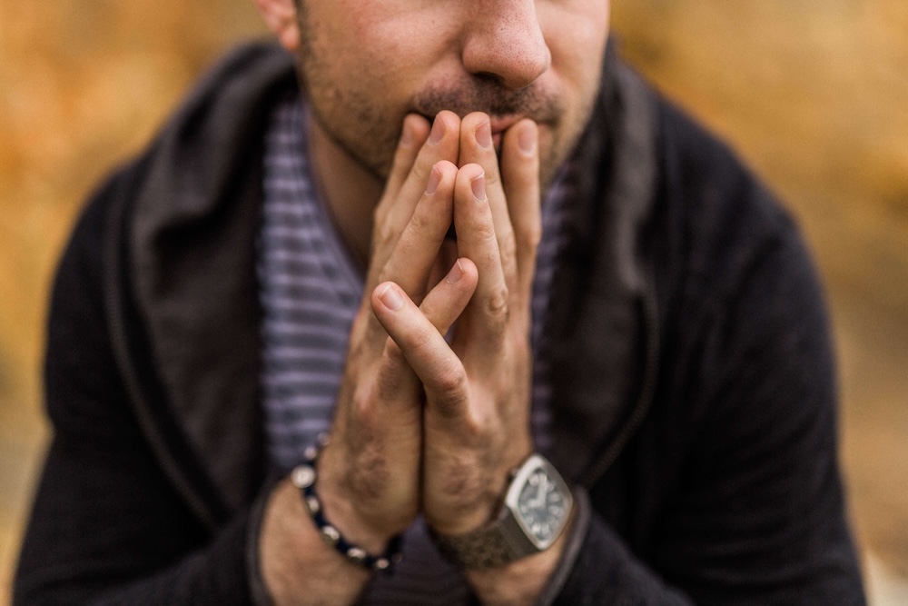 Image of a man holding his hands to his mouth feeling anxious. Discover how you can heal from your anxiety symptoms with the help of EMDR therapy in Las Vegas, NV and Torrance, CA.