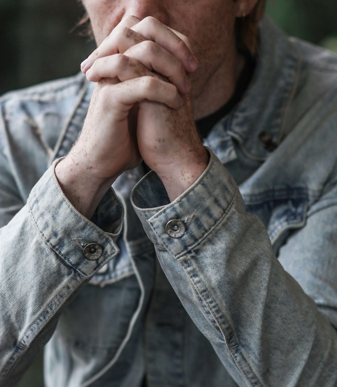 Image of a man wearing a jean jacket, resting his clasped hands against his mouth. Work to effectively manage your phobias with the help of EMDR therapy in Las Vegas, NV.