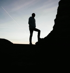 Image of a man on a hike resting his foot on a rock. Discover how EMDR therapy in Las Vegas, NV can help you explore your attachment style.