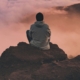 Image of a man sitting on a rock looking over the clouds. Learn how EMDR therapy in Las Vegas, NV can help you cope with trauma.