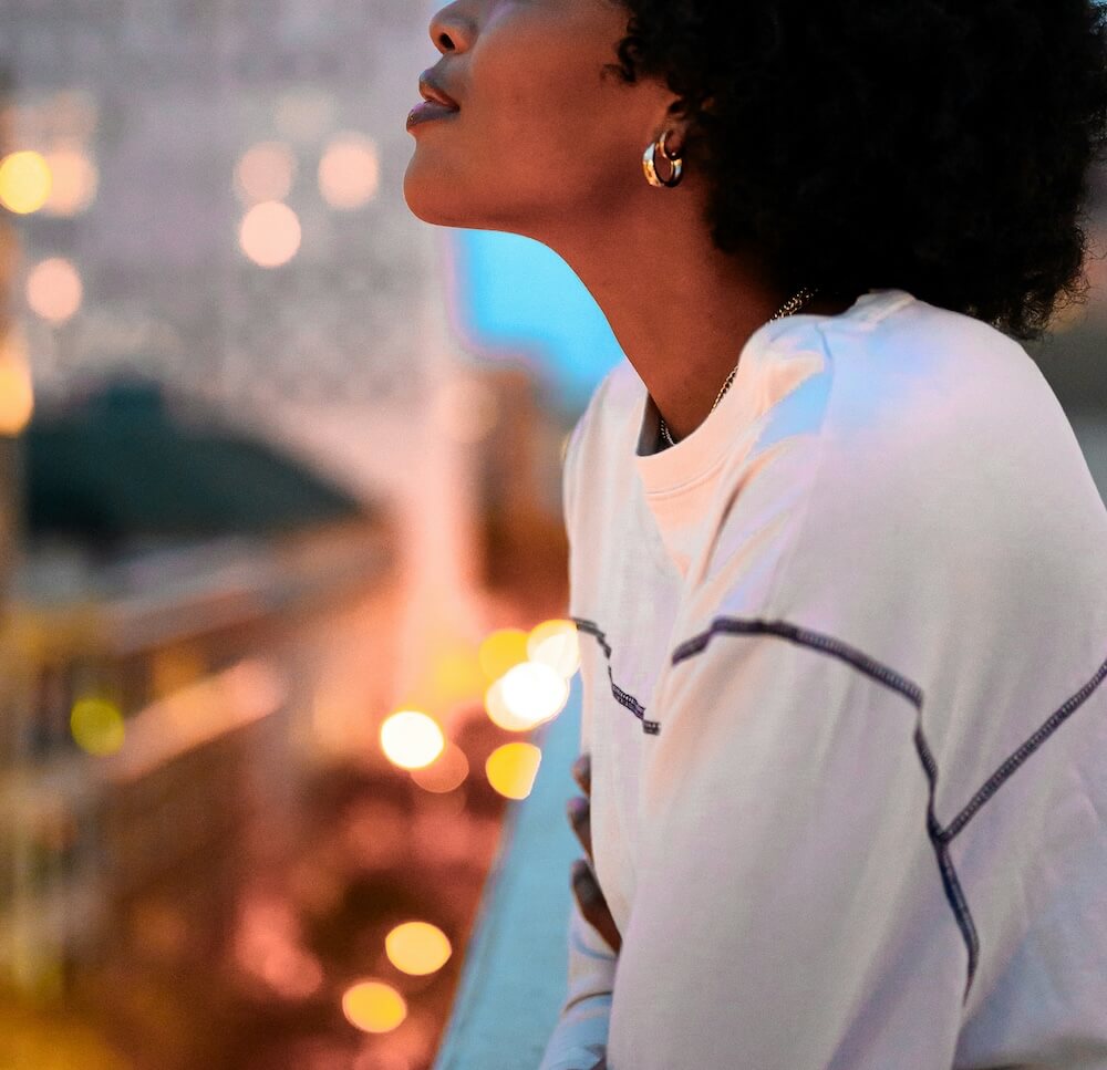 Image of a peaceful woman closing her eyes and looking up above a busy city. Discover your attachment style and learn to cope with the help of EMDR therapy in Las Vegas, NV.