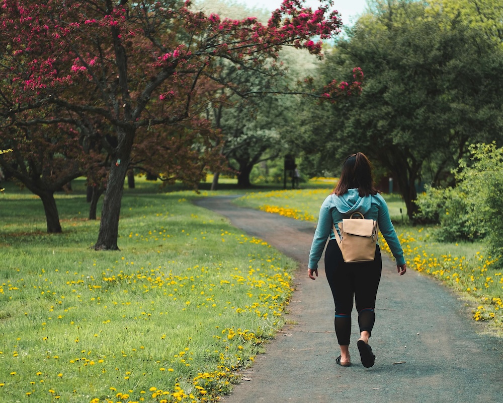 Image of a woman walking down a path in a park. Explore your attachment style with the help of EMDR therapy in Las Vegas, NV.