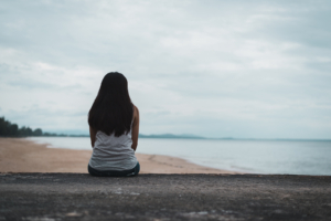 A woman sits alone while overlooking a cloudy shore. This could represent the pain of isolation that emdr therapy in anxiety in las vegas, nv and CA can address. Learn more about emdr therapy in torrance, ca by contacting an EMDR therapist in las vegas, nv today.