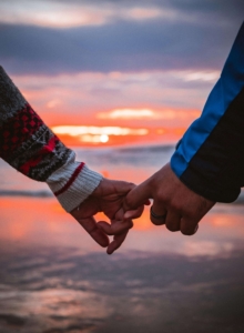 Shows a couple holding pinkies in front of the sunset. Represents how a dbt therapist in las vegas and dbt therapy in las vegas can help you work through negative feelings.
