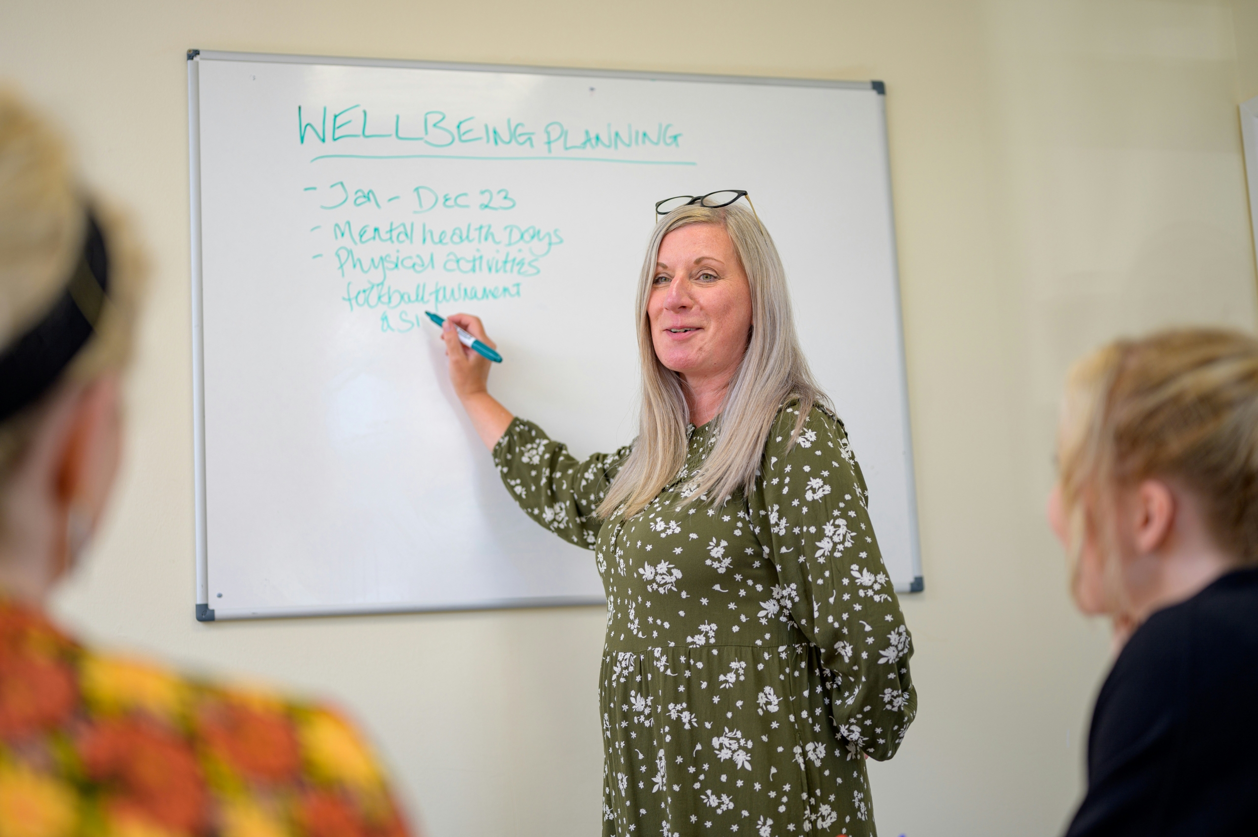 Facilitator leading a DBT skills training group with adults seated around a conference table