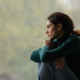 Woman sitting by a window, deep in thought, symbolizing emotional reflection and readiness for EMDR therapy