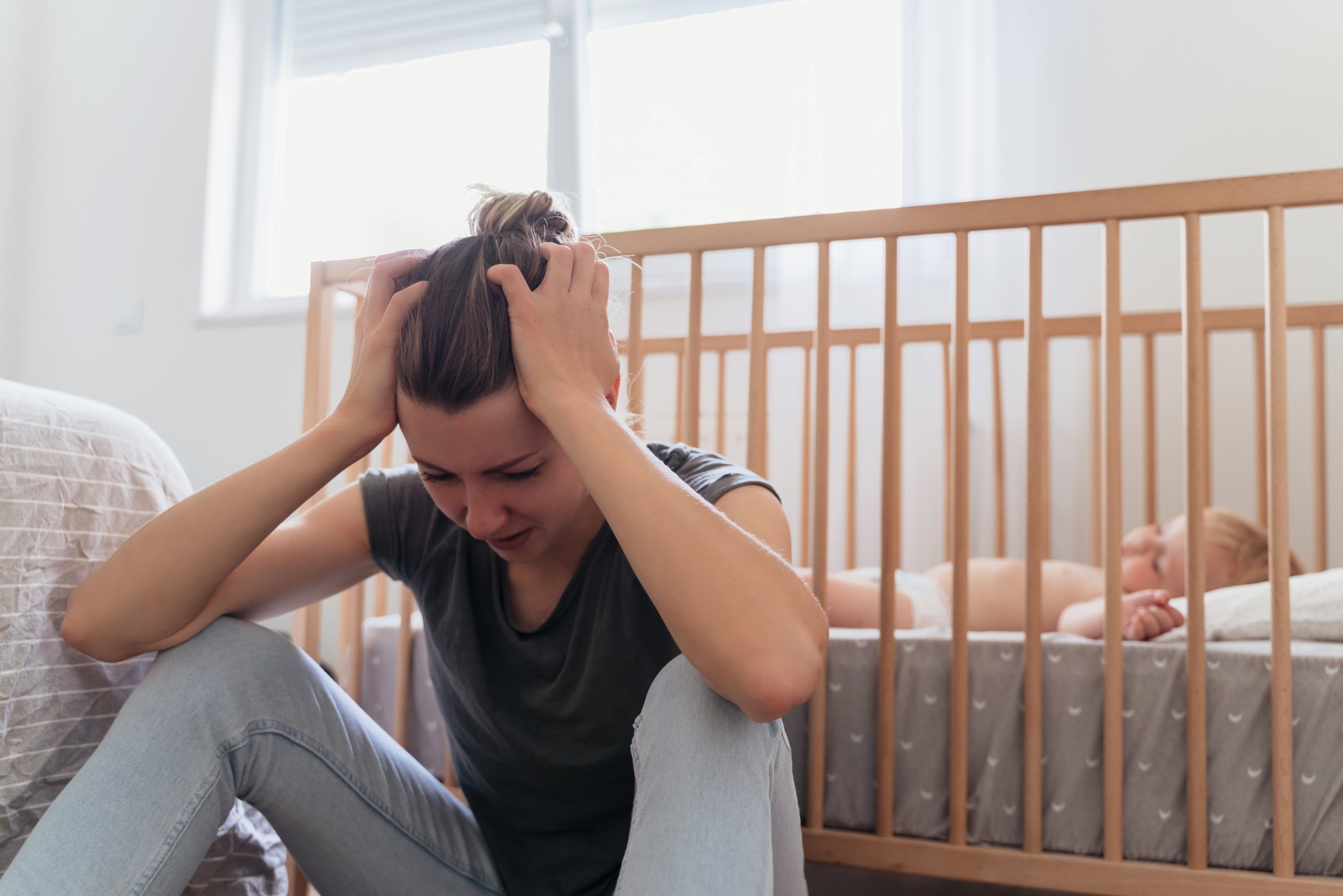 Baby appearing unsettled while lying alone, representing insecure attachment when comfort feels difficult.