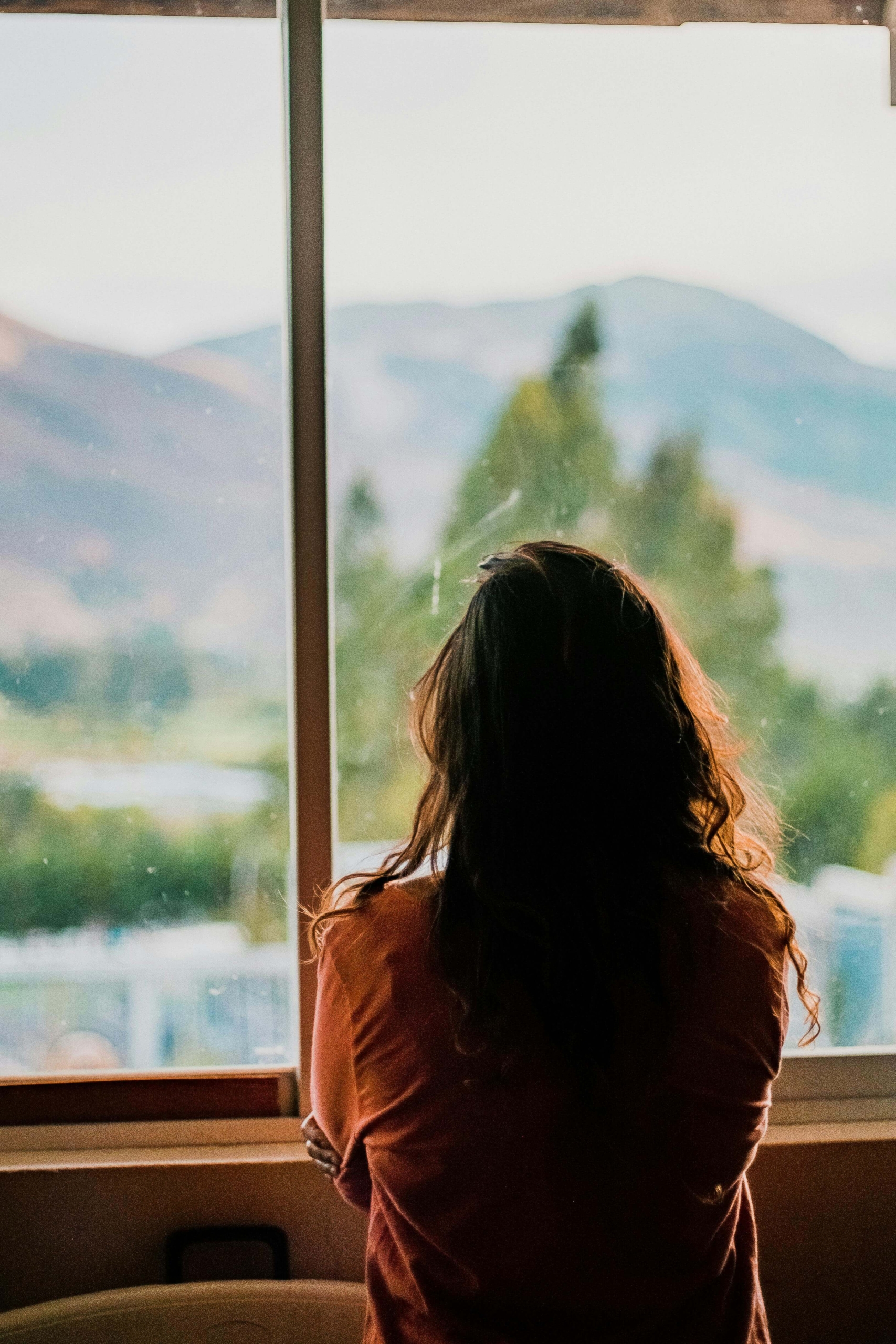 A woman standing by a window, looking out at the mountains. Do you want to strengthen your DBT skills and plan ahead for difficult situations? DBT therapy in Las Vegas, NV, can help you build emotional resilience and prepare for stress.