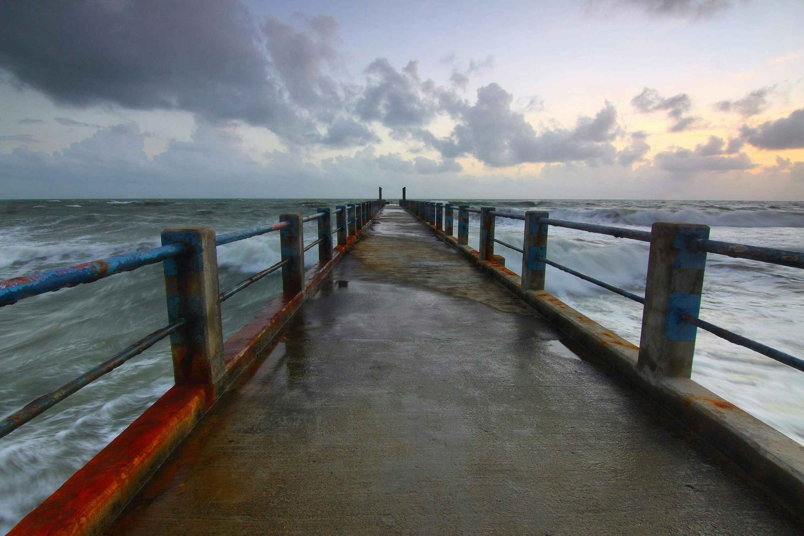 A pier stretches into the ocean beneath stormy skies, symbolizing the emotional turbulence that DBT therapy helps calm. Working with a DBT therapist in Las Vegas, NV, can support mindfulness and emotional safety through structured healing practices.