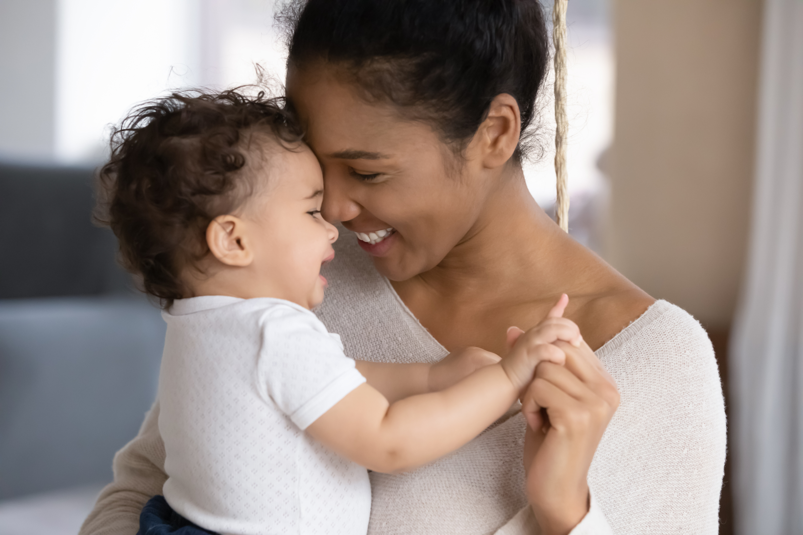 Baby held securely by caregiver, showing comfort and trust in early attachment.