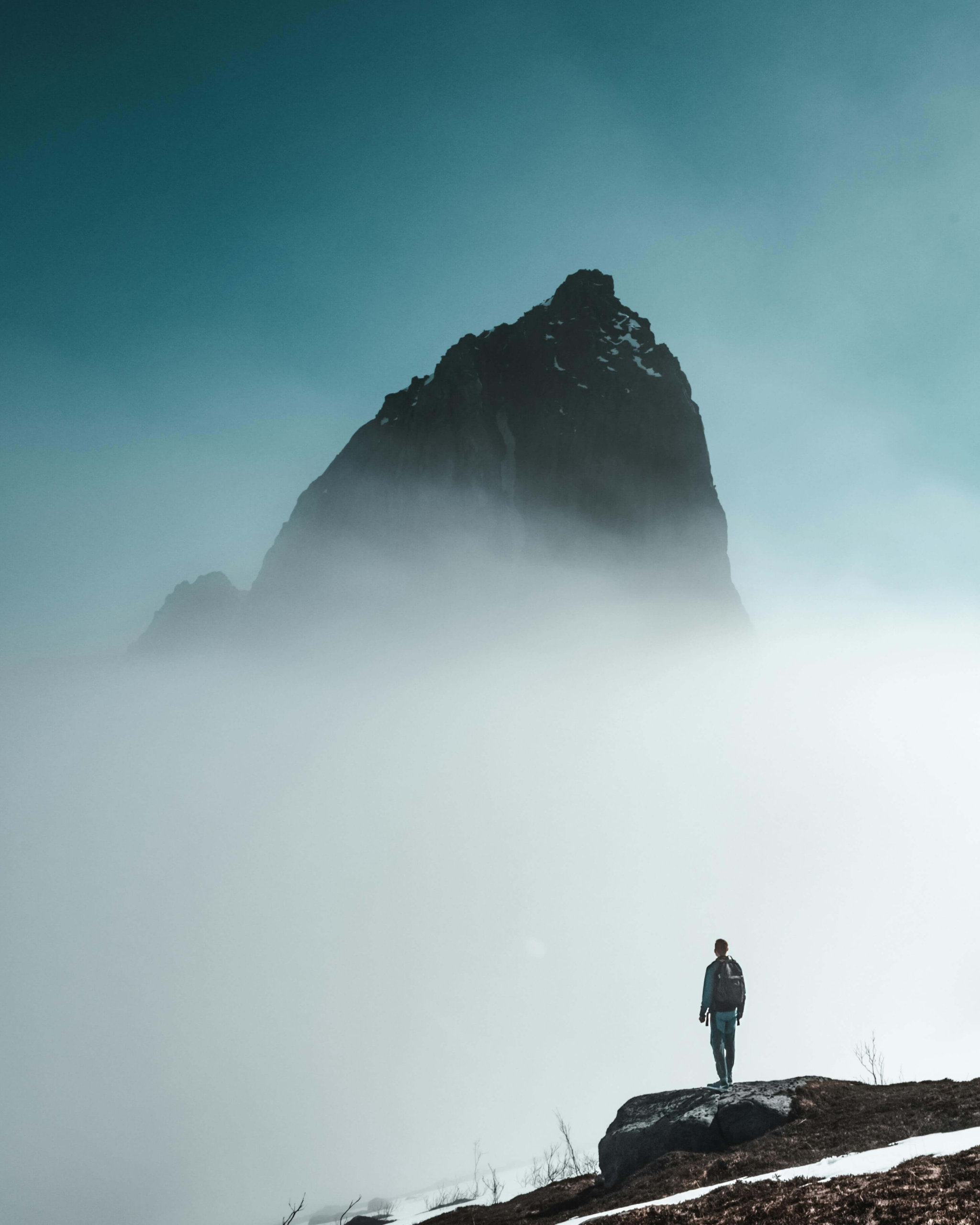 A person stands on a mountain ledge surrounded by mist, symbolizing mindfulness and emotional awareness. Learning to stay present with each current emotion is key to healing. Learn how online DBT therapy in Las Vegas, NV, teaches grounding techniques.