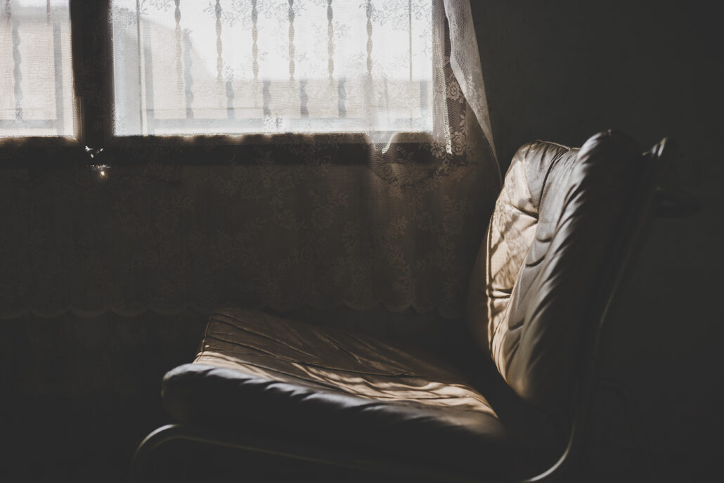 Empty armchair beside a window with soft afternoon light